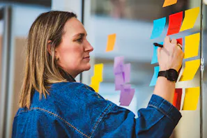 Lait projektleder Sara skriver noter på post its